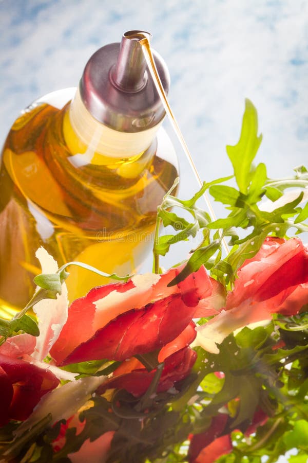 Pouring olive oil on Bresaola Salad