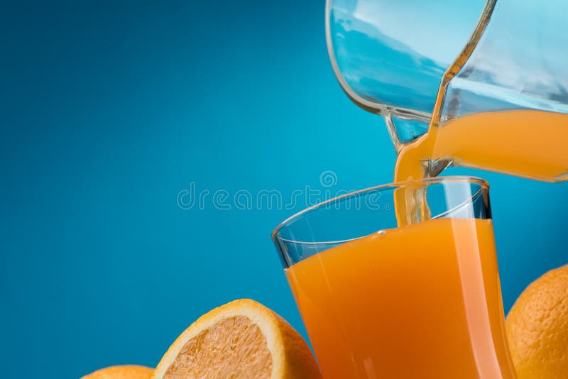 Pouring orange juice into a glass and sliced fresh oranges, vitamins and healthy drinks concept