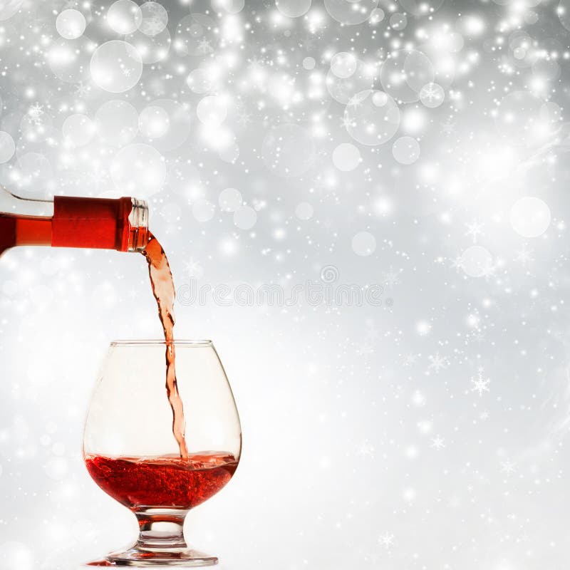 Pouring red wine against holiday lights