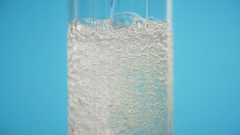 Pouring soda in glass blue background refreshing drink clean sparkling water