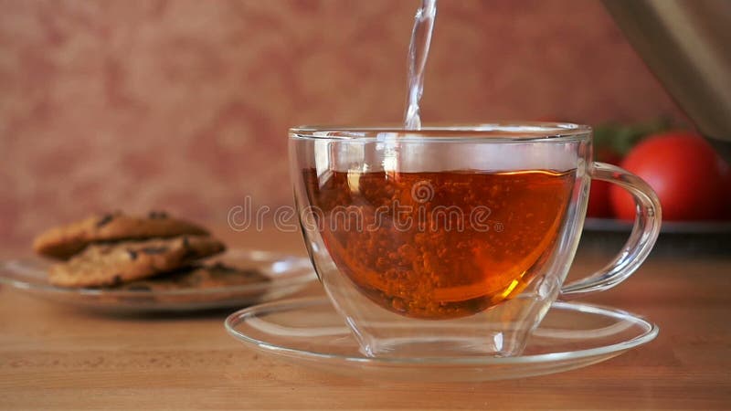Pouring tea into a glass cup on a table. Hot cafe video
