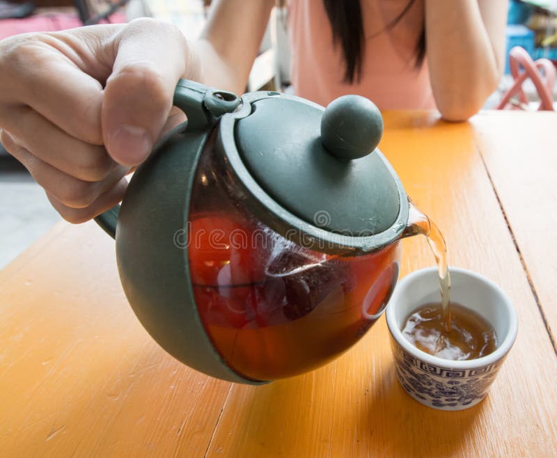 Pouring tea into cup of tea