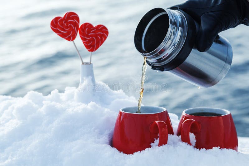 Pouring Tea from a Thermos in the on a Picnic on Valentine`s Day