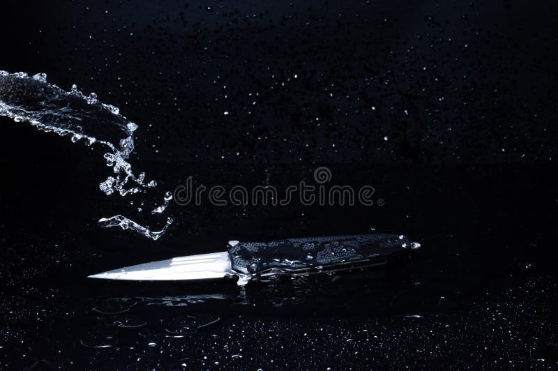 Pouring Water Onto a Spearshaped Knife. Splashes of Water Around the