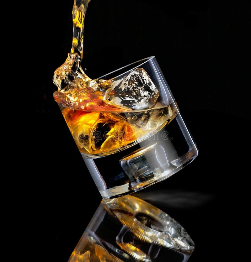 Premium Photo  Pouring whisky from a jigger into a rocks glass with a big  ice cube