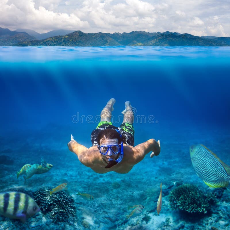 Pousse sous-marine d'un jeune homme naviguant au schnorchel en mer tropicale dessus image libre de droits Pousse sous-marine d'un jeune homme naviguant au schnorchel en mer tropicale dessus image libre de droits