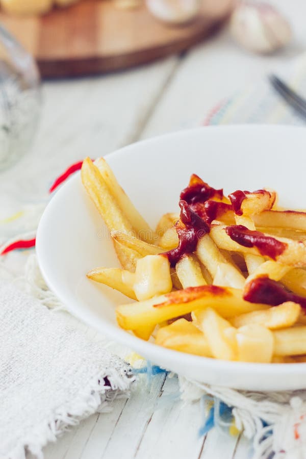 Poutine fait frire avec la sauce tomate et le fromage sur la table blanche photographie stock libre de droits Poutine fait frire avec la sauce tomate et le fromage sur la table blanche photographie stock libre de droits