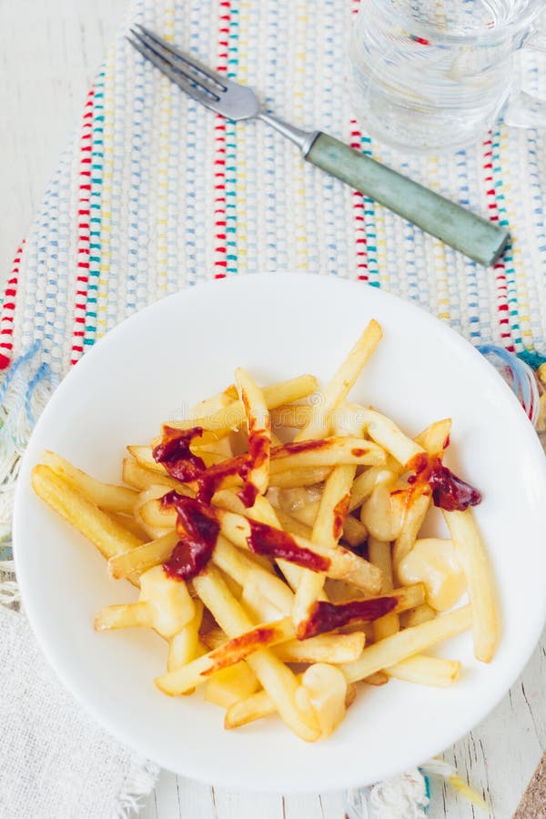 Poutine fait frire avec la sauce tomate et le fromage sur la table blanche photos stock Poutine fait frire avec la sauce tomate et le fromage sur la table blanche photos stock