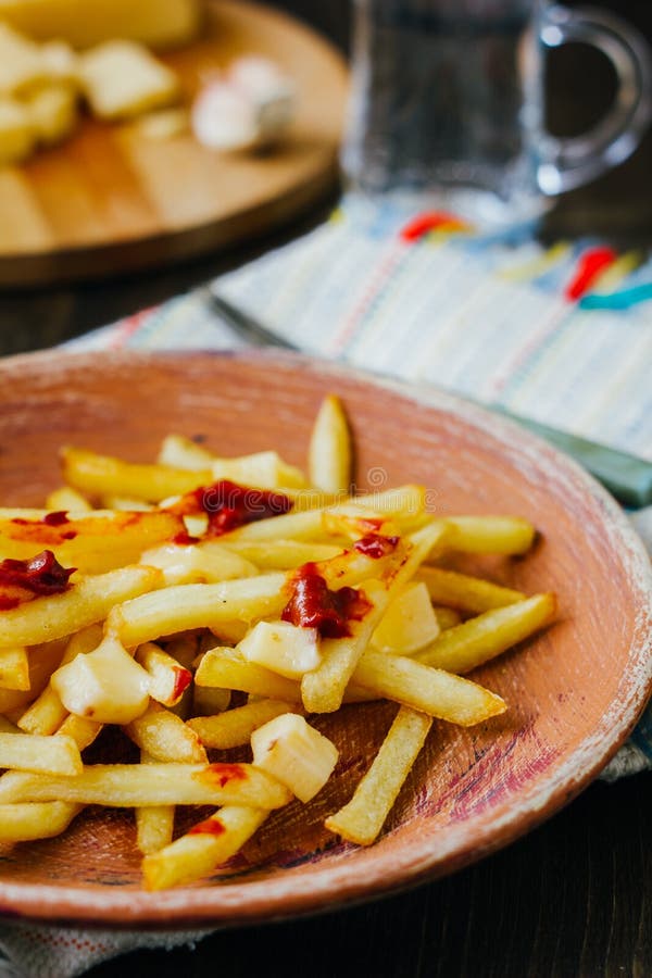 Poutine Fries on Black Surface. Canadian Dish with Potatoes, Cheese and