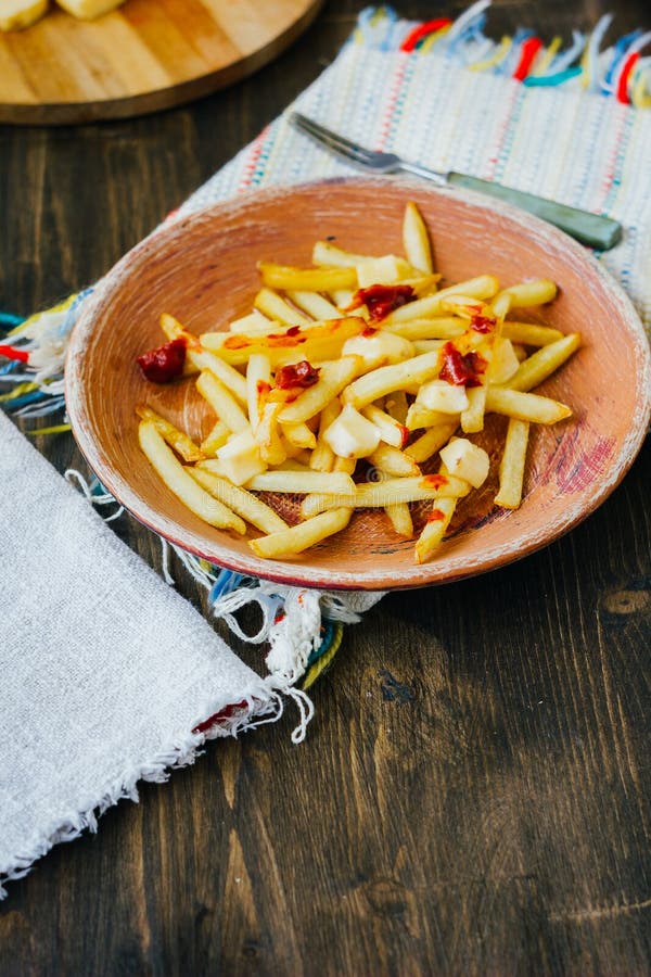 Poutine Fries On Black Surface. Canadian Dish With Potatoes, Cheese And