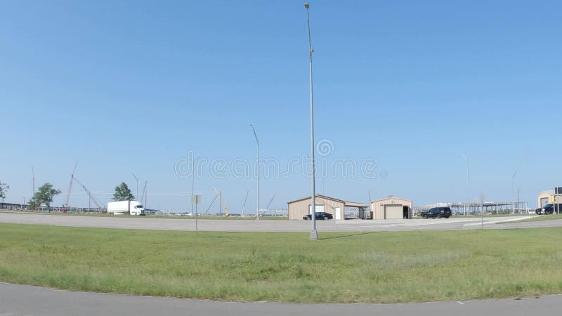 Pov drive street pan área masiva de construcción con docenas de grúas y una estación de pesas de camiones