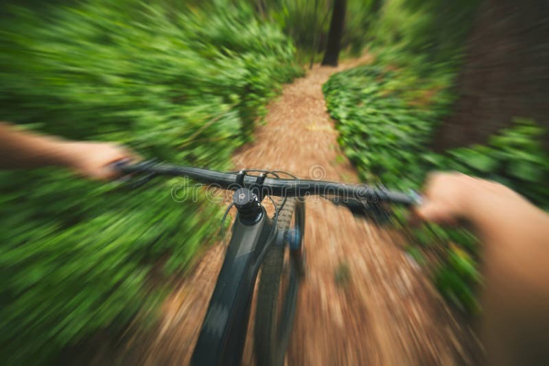 POV, mountain bike and sports person in forest, park and path for adventure, speed and motion blur. Closeup perspective