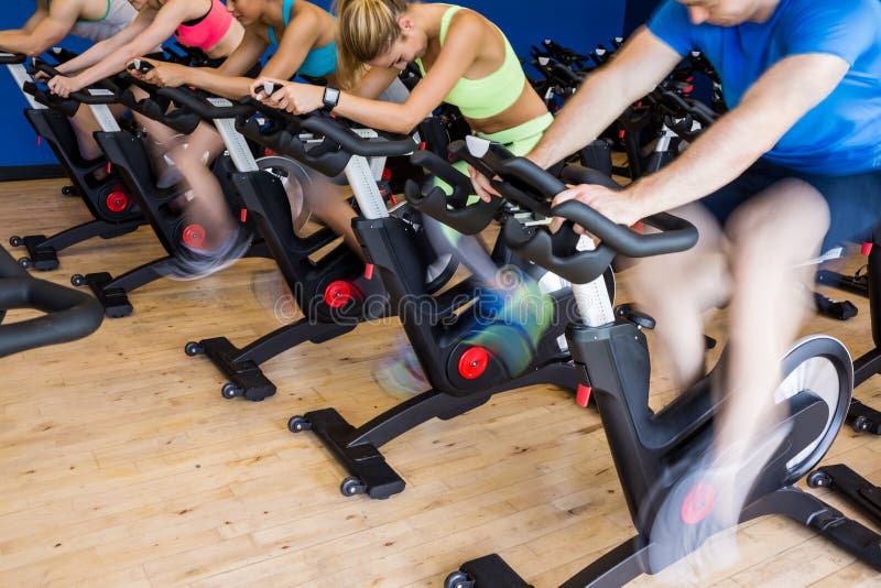 Fit people in a spin class at the gym. Fit people in a spin class at the gym