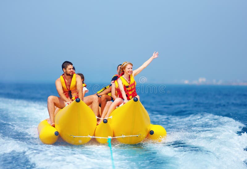 Povos felizes que têm o divertimento no barco de banana