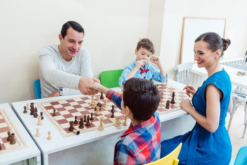 Escola de xadrez xadrez infantil concentrado jogo infantil inteligente  xadrez na biblioteca perto das estantes conceito educacional menino  pensando em xadrez o conceito de aprender e crescer crianças