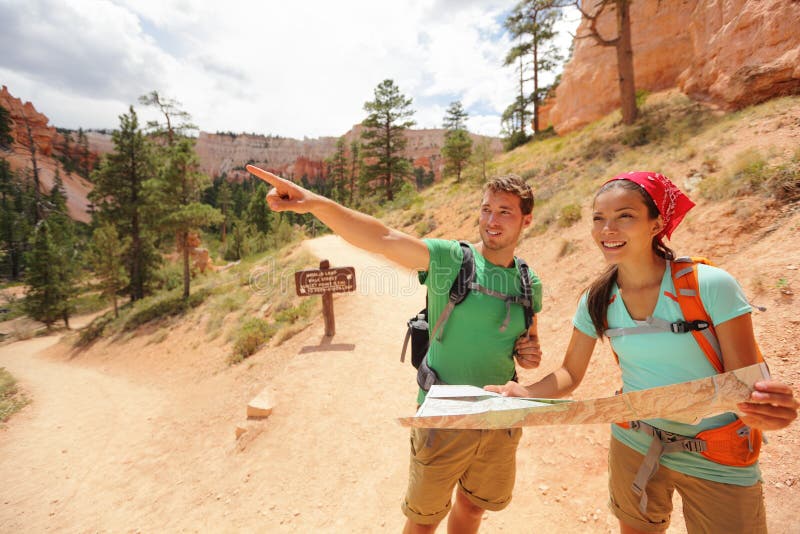 Povos que caminham olhando o mapa da caminhada em Bryce Canyon foto de stock Povos que caminham olhando o mapa da caminhada em Bryce Canyon foto de stock