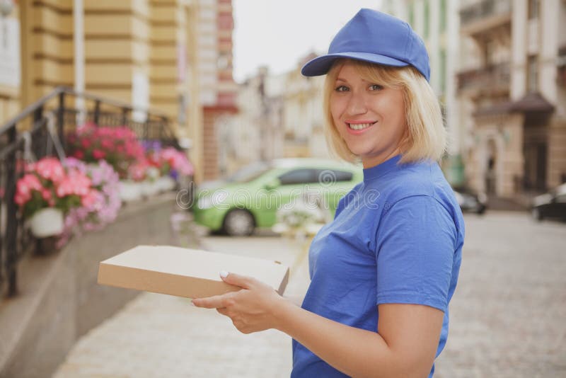 Powabna doręczeniowa kobieta z pizzy pudełkiem obrazy stock Powabna doręczeniowa kobieta z pizzy pudełkiem obrazy stock