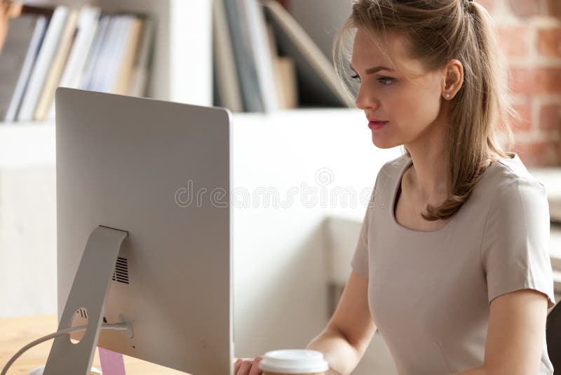 Poważnego żeńskiego pracownika ruchliwie działanie przy komputerem w biurze fotografia royalty free Poważnego żeńskiego pracownika ruchliwie działanie przy komputerem w biurze fotografia royalty free