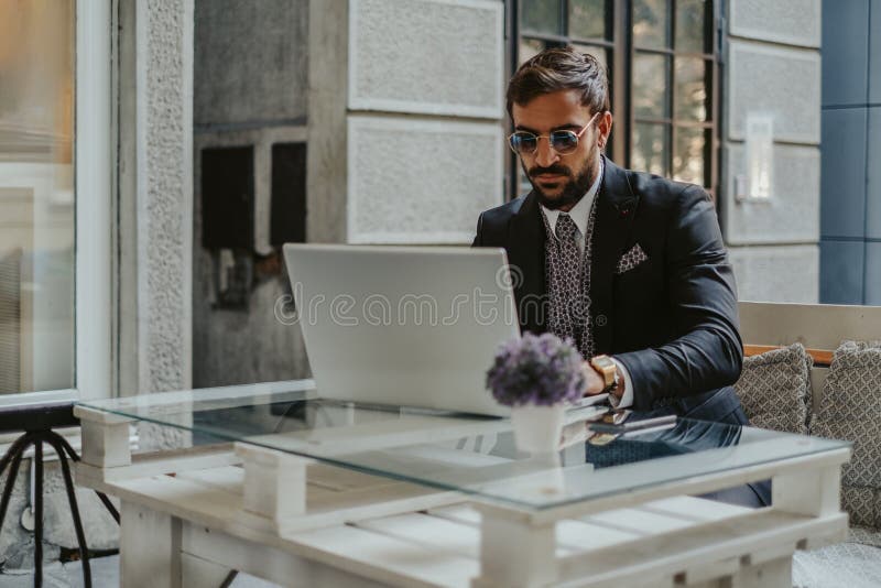 Poważny biznesmen pracuje na laptopie w kawiarni zdjęcie stock Poważny biznesmen pracuje na laptopie w kawiarni zdjęcie stock