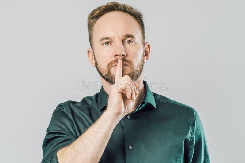 Poważny caucasian mężczyzny mienia palec wskazujący nad usta mówi shh