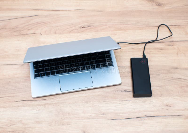 Power Bank with Usbc Cable is Charging Laptop . Modern, Information Technology Stock Image