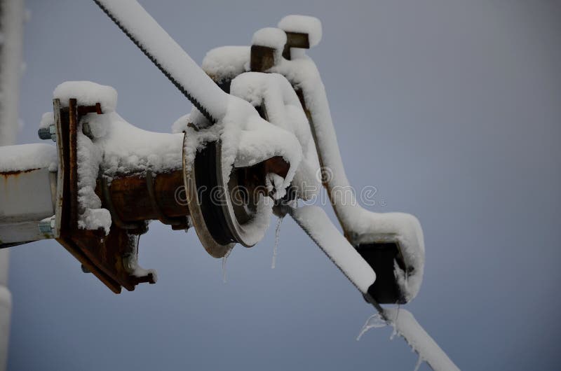 Power lines frozen by a large layer of ice layer in the shape of a cylinder with icicles. icing burdens the poles, ladder and ligh royalty free stock photos