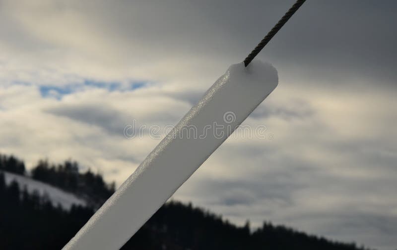 Power lines frozen by a large layer of ice in the shape of a cylinder with icicles. icing loads the columns, which are overloaded royalty free stock photos