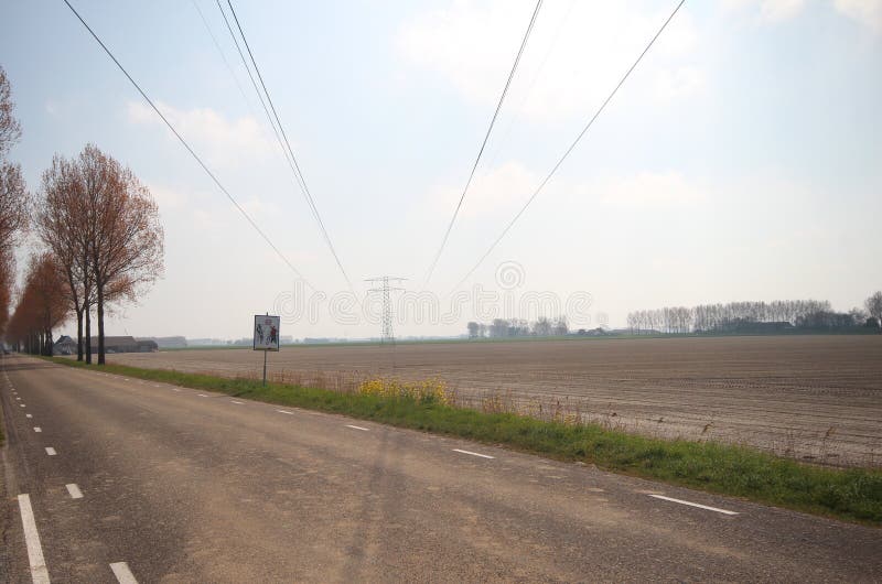 Power lines with tower in the sun in Den Bommel on island Goeree Overflakkee in the Netherlands. royalty free stock image Power lines with tower in the sun in Den Bommel on island Goeree Overflakkee in the Netherlands. royalty free stock image