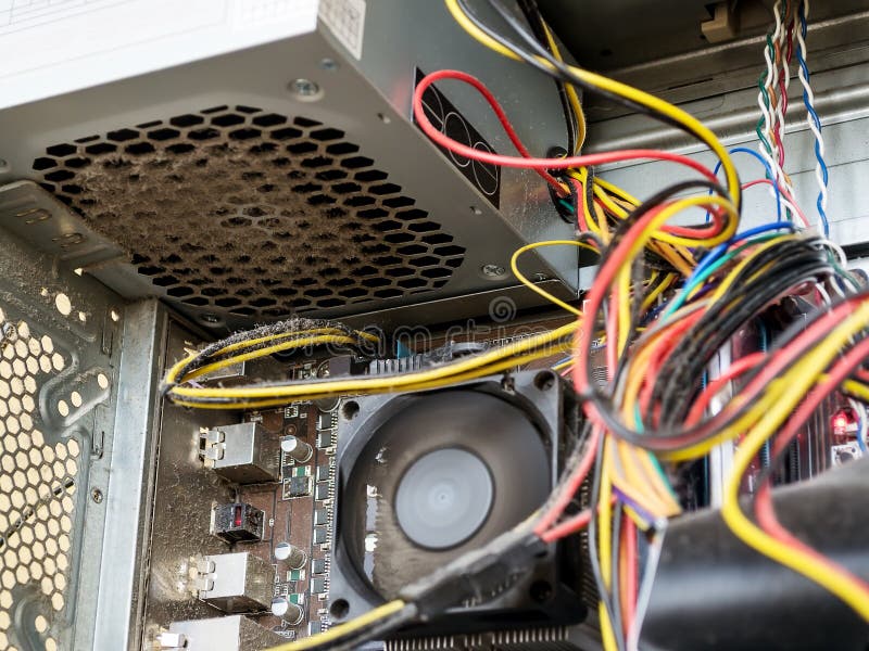 Power supply and wires inside of the personal computer case are covered with dust. A lot of dust under the cooler on the processor stock photos