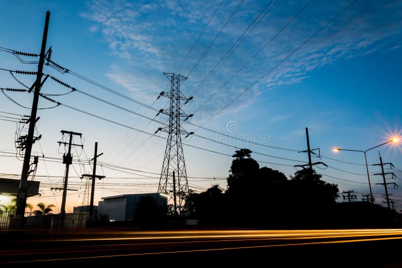Power Transmission Tower during Twilight Time and Car Lights Stock