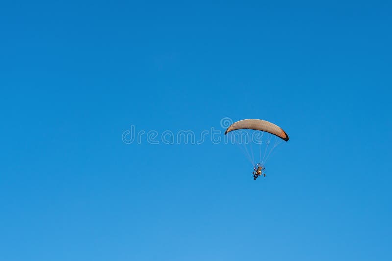 A Powered Paraglider Trike Flying Over Clear Blue Sky Back View Stock Photo Image of flight