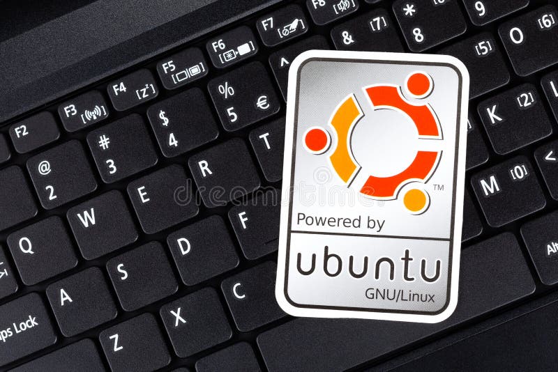 Powered by Ubuntu GNU Linux operating system sticker, logo symbol label closeup, laptop keyboard. Debian open source software stock photos