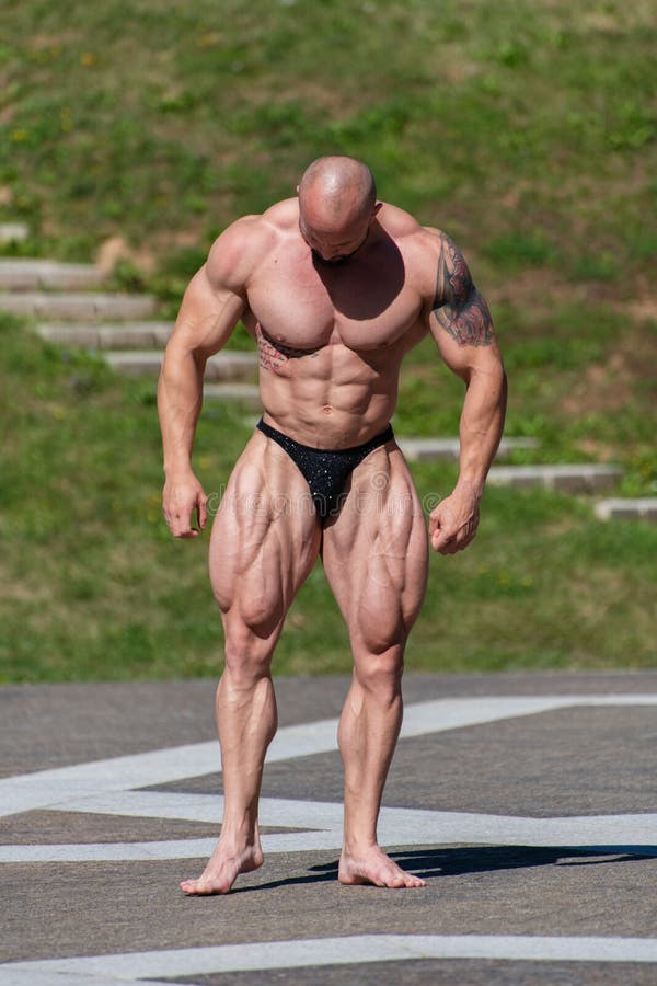 Powerful Muscular Bodybuilder in Panties Posing at the Park. Quadriceps