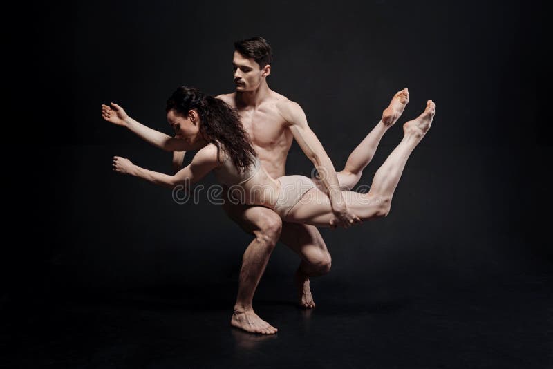 Powerful young athletes performing in front of the black wall stock image