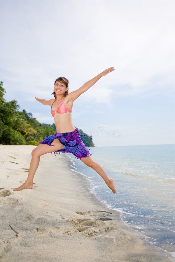 Young woman jumping happilly at the beach. Young woman jumping happilly at the beach