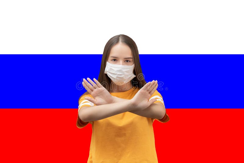 Powstrzymywanie koronawirusa w Rosji Dziewczyna w antybakteryjnej masce medycznej pokazuje skrzyżowane ręce na tle flagi obraz stock Powstrzymywanie koronawirusa w Rosji Dziewczyna w antybakteryjnej masce medycznej pokazuje skrzyżowane ręce na tle flagi obraz stock