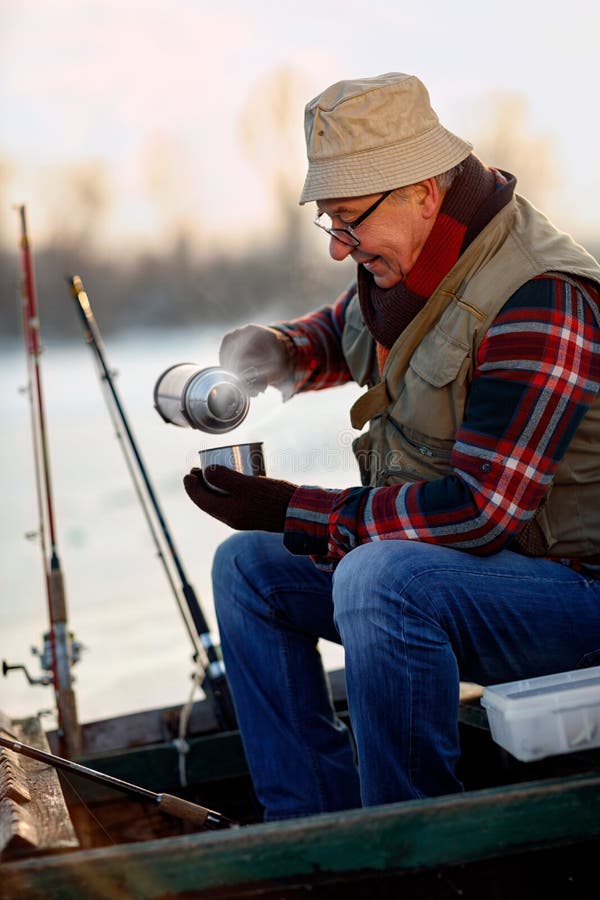 Ice fishing. senior man on frozen lake and drink hot tea. Ice fishing. senior man on frozen lake and drink hot tea