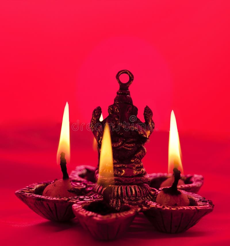 Beautifully lit lamps around Hindu Lord Ganesh. Beautifully lit lamps around Hindu Lord Ganesh