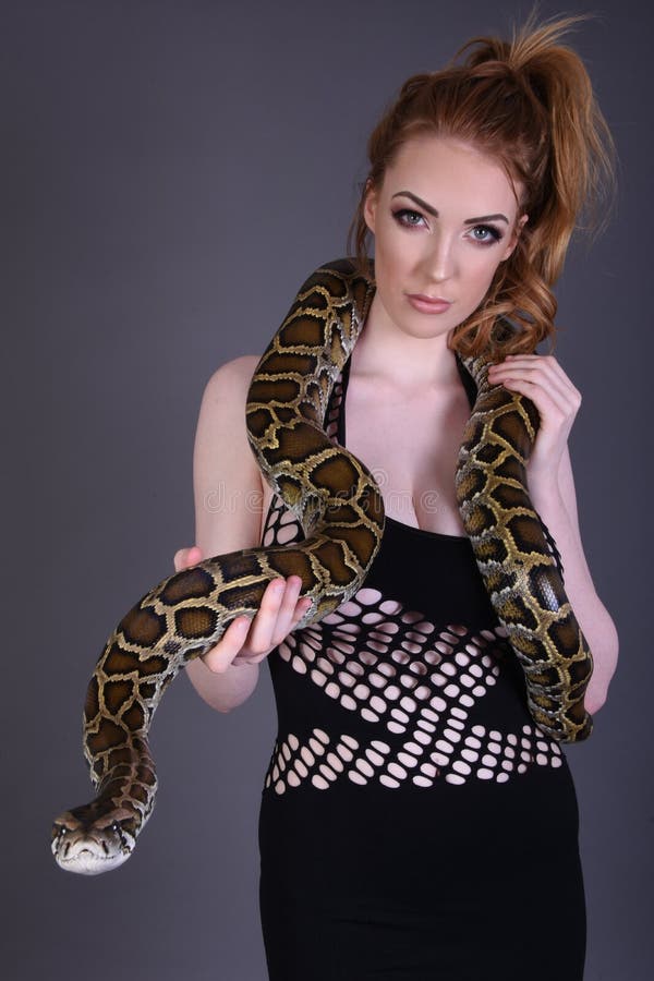 Prachtig groot slim bosty redhead model in een sexy zwarte maas jurk met een slang