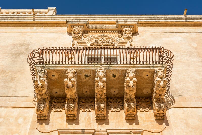 Prachtige antieke barokbalkon met paardenversiering in Noto, Sicilië, Italië stock afbeelding Prachtige antieke barokbalkon met paardenversiering in Noto, Sicilië, Italië stock afbeelding