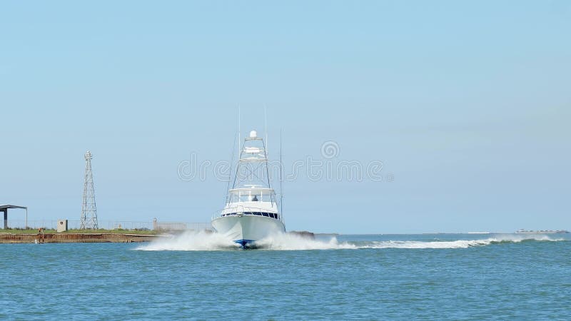 Prachtige clip van een witte vissersboot op blauw water terwijl hij zich omdraait en vertraagt om de haven binnen te varen op een