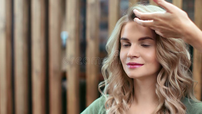 Prachtige vrouw in modessalon tijdens het maken van haar kapsel. Foto van de camera van de rode 4.000 film