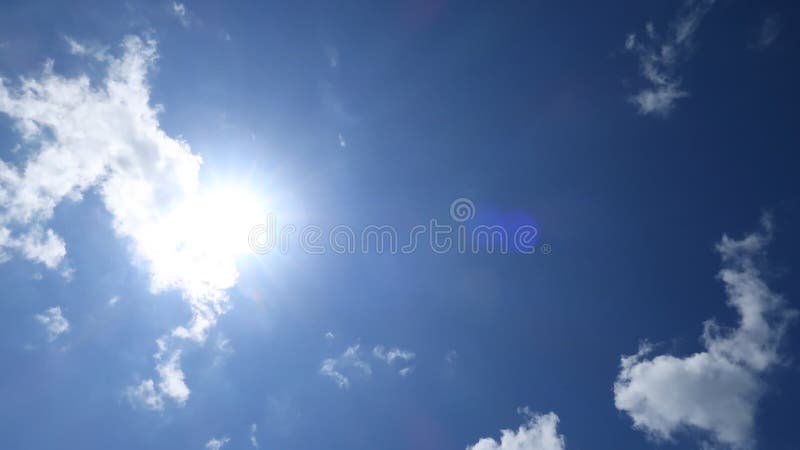 Prachtige zonnige blauwe hemel met zonlicht dat door witte wolken schijnt