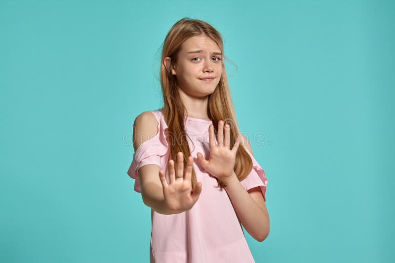 Pracowniany portret piękny dziewczyny blondynki nastolatek w różowej koszulce pozuje nad błękitnym tłem obrazy stock Pracowniany portret piękny dziewczyny blondynki nastolatek w różowej koszulce pozuje nad błękitnym tłem obrazy stock