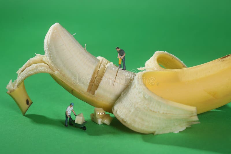 Pracownicy Budowlani w Konceptualny Karmowy metaforyka Z bananem zdjęcia stock