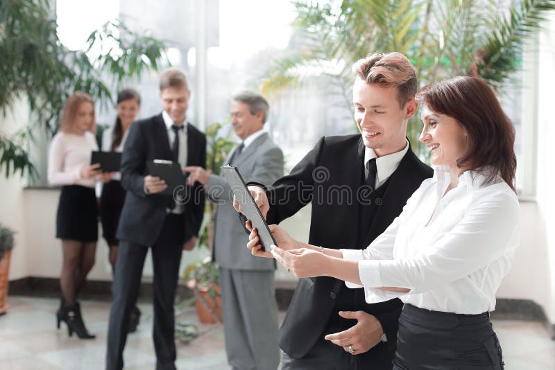 Pracownicy firma stoi w lobby biuro z schowkami fotografia stock Pracownicy firma stoi w lobby biuro z schowkami fotografia stock