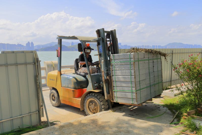 Pracownik budowy przewieziony kamień forklift fotografia stock Pracownik budowy przewieziony kamień forklift fotografia stock