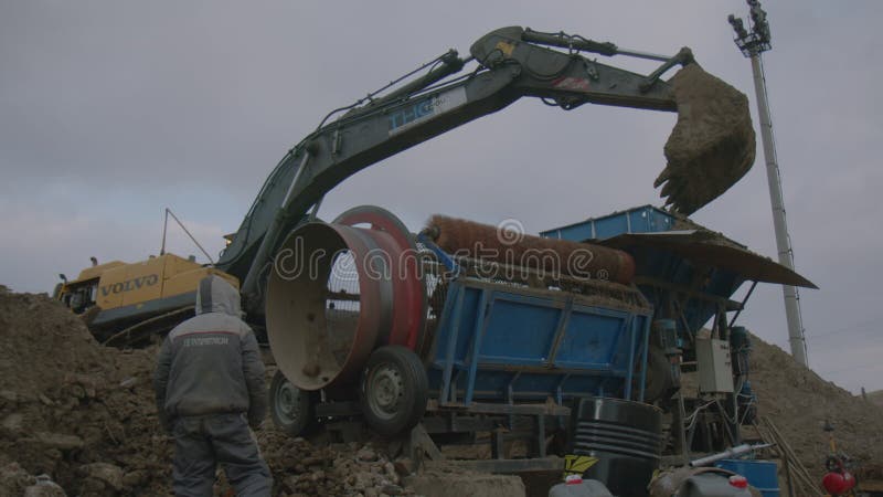 Pracownik kontroluje piasek szlifierski separatora maszyny w miejscu pracy