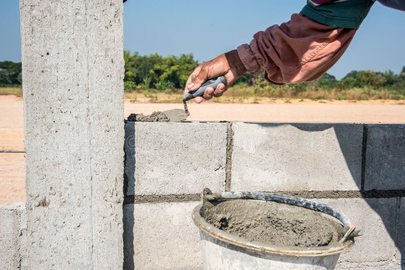 Pracownik robi betonowej ścianie cementem blokować i gipsować