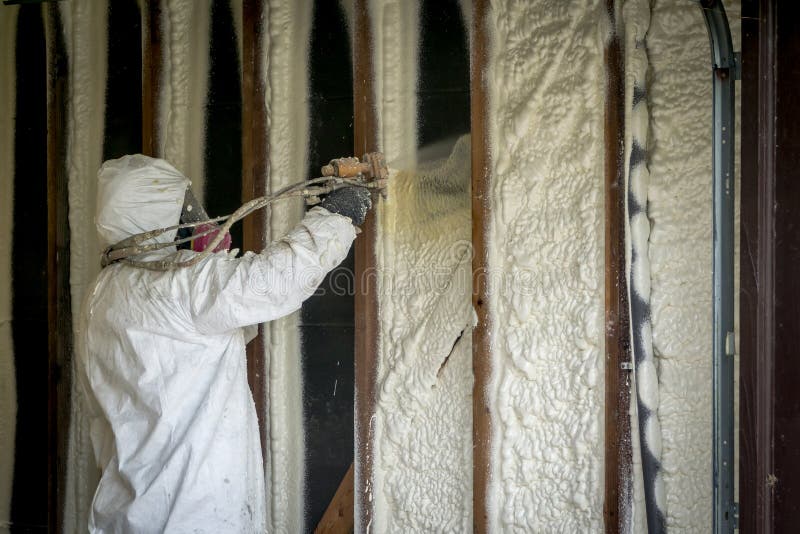 Pracownika opryskiwanie zamykał komórki kiści piany izolację na dom ścianie